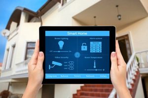 Contact — hands holding tablet with home security app in front of house in Redwood City, CA